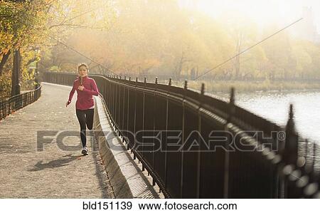 Asian woman running on waterfront path View Large Photo Image Stock Photo - Asian woman running on waterfront path. Fotosearch