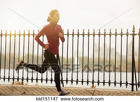 Asian woman running on waterfront path View Large Photo Image Stock Photo - Asian woman running on waterfront path. Fotosearch