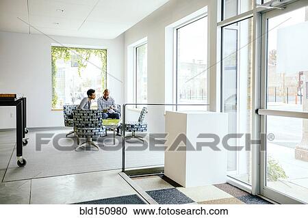Stock Image - Black business people talking in office lobby. Fotosearch