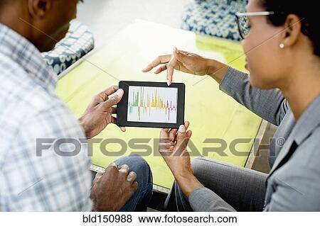Stock Photo - Black business people using digital tablet in office lobby. Fotosearch