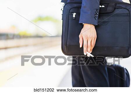 Black businessman holding cigarette outdoors View Large Photo Image Stock Image - Black businessman holding cigarette outdoors. Fotosearch
