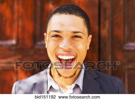 Stock Image - Black businessman smiling outdoors. Fotosearch