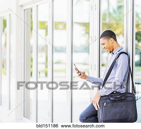 Black businessman using cell phone outdoors View Large Photo Image Stock Photograph - Black businessman using cell phone outdoors. Fotosearch