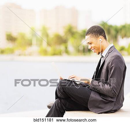 Stock Image - Black businessman using digital tablet outdoors. Fotosearch