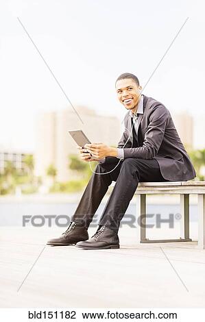 Black businessman using digital tablet outdoors View Large Photo Image Stock Image - Black businessman using digital tablet outdoors. Fotosearch