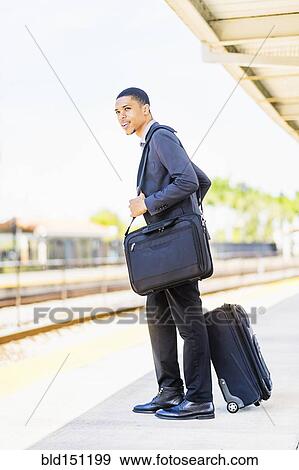Stock Photo - Black businessman waiting on train platform. Fotosearch