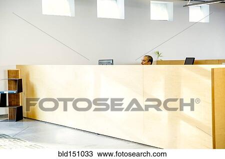 Stock Image - Black businessman working in office cubicle. Fotosearch