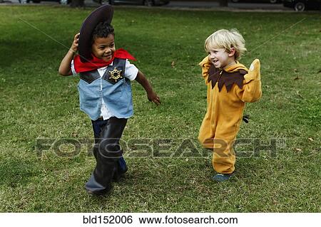 Stock Photograph - Boys playing in costumes in park. Fotosearch