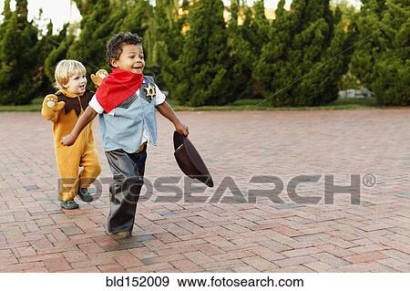 Boys playing in costumes on sidewalk View Large Photo Image Stock Photo - Boys playing in costumes on sidewalk. Fotosearch