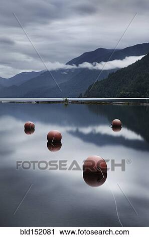 Stock Image - Buoys floating in still remote lake. Fotosearch