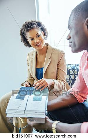 Stock Photo - Business people examining swatches in office lobby. Fotosearch
