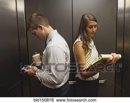 Stock Photo - Business people ignoring each other in elevator. Fotosearch