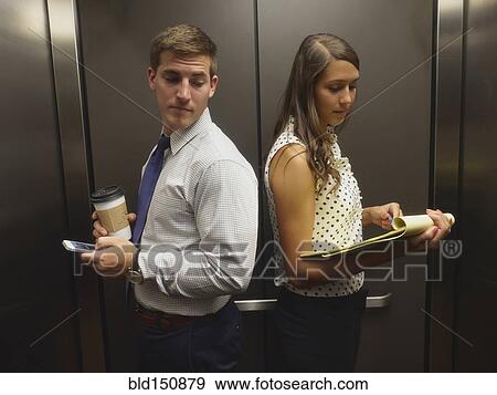 Business people ignoring each other in elevator View Large Photo Image Stock Photo - Business people ignoring each other in elevator. Fotosearch