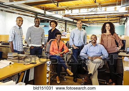 Stock Image - Business people smiling in office. Fotosearch