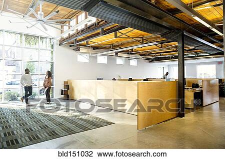 Stock Image - Business people talking in office lobby. Fotosearch