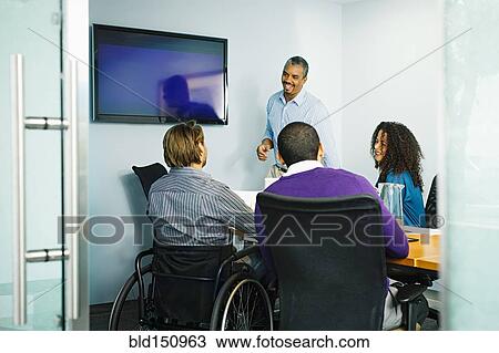 Stock Image - Business people talking in office meeting. Fotosearch