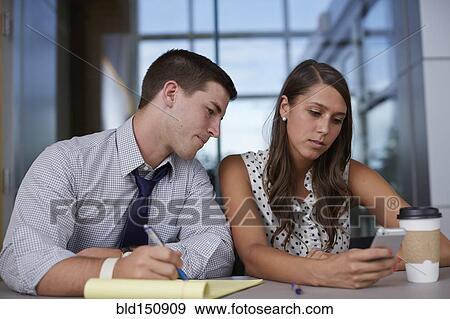 Business people using cell phone in office meeting View Large Photo Image Stock Photo - Business people using cell phone in office meeting. Fotosearch
