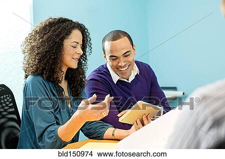 Picture - Business people using digital tablet in office meeting. Fotosearch