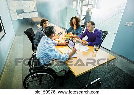 Business people using digital tablets in office meeting View Large Photo Image Stock Photograph - Business people using digital tablets in office meeting. Fotosearch