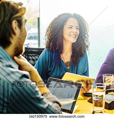 Stock Photography - Business people using digital tablets in office meeting. Fotosearch