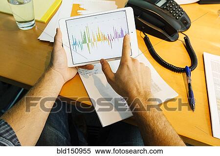Stock Photography - Businessman using digital tablet at desk. Fotosearch