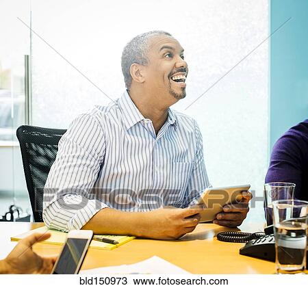 Businessman using digital tablet in office meeting View Large Photo Image Stock Image - Businessman using digital tablet in office meeting. Fotosearch