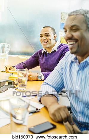 Businessmen laughing in office meeting View Large Photo Image Stock Image - Businessmen laughing in office meeting. Fotosearch