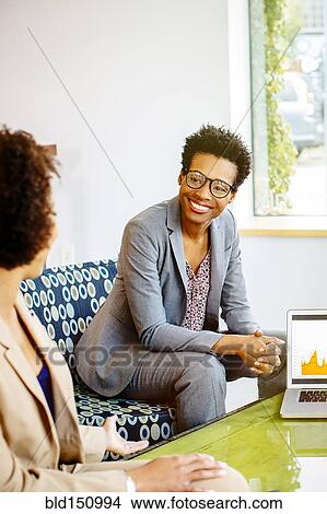 Businesswomen talking in office lobby View Large Photo Image Picture - Businesswomen talking in office lobby. Fotosearch