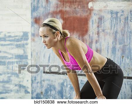 Stock Photo - Caucasian athlete resting in warehouse. Fotosearch