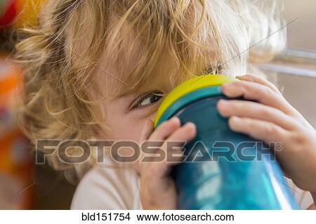 Picture - Caucasian baby drinking water from cup. Fotosearch