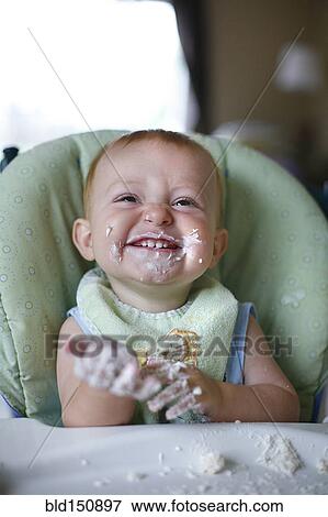 Caucasian baby eating cake in high chair View Large Photo Image Stock Photo - Caucasian baby eating cake in high chair. Fotosearch