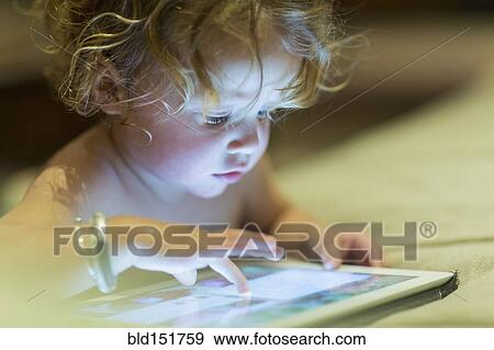 Caucasian baby using digital tablet View Large Photo Image Stock Photo - Caucasian baby using digital tablet. Fotosearch