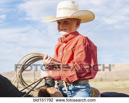 Caucasian boy on horse carrying lasso View Large Photo Image Stock Image - Caucasian boy on horse carrying lasso. Fotosearch