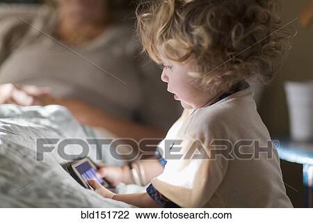 Stock Image - Caucasian boy playing with cell phone. Fotosearch