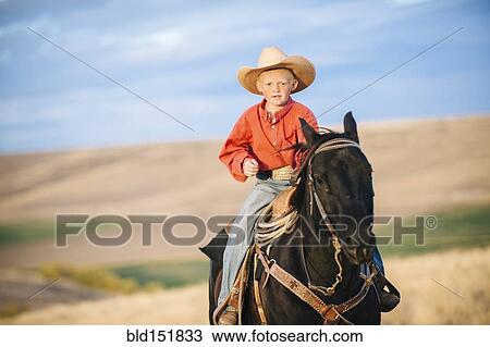 Caucasian boy riding horse in grassy field View Large Photo Image Stock Image - Caucasian boy riding horse in grassy field. Fotosearch