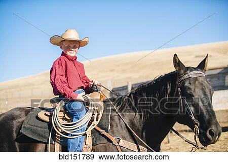 Stock Photo - Caucasian boy riding horse on ranch. Fotosearch