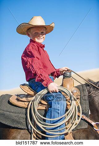Stock Photo - Caucasian boy riding horse. Fotosearch