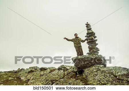 Stock Image - Caucasian boy smiling near stack of rocks. Fotosearch