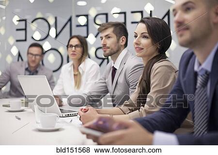 Stock Photo - Caucasian business people listening in office meeting. Fotosearch