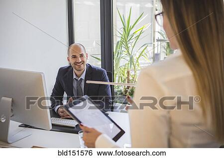 Stock Photograph - Caucasian business people talking in office. Fotosearch