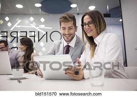 Caucasian business people using digital tablet in office meeting View Large Photo Image Stock Image - Caucasian business people using digital tablet in office meeting. Fotosearch