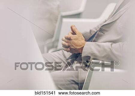 Caucasian businessman sitting in chair with hands clasped View Large Photo Image Stock Image - Caucasian businessman sitting in chair with hands clasped. Fotosearch
