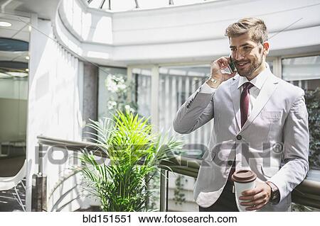 Caucasian businessman talking on cell phone on office balcony View Large Photo Image Stock Image - Caucasian businessman talking on cell phone on office balcony. Fotosearch