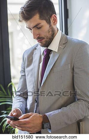Stock Image - Caucasian businessman using cell phone. Fotosearch