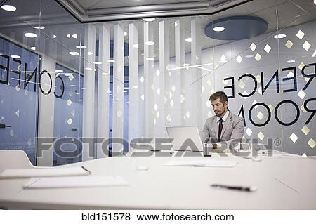 Stock Photo - Caucasian businessman working in conference room. Fotosearch