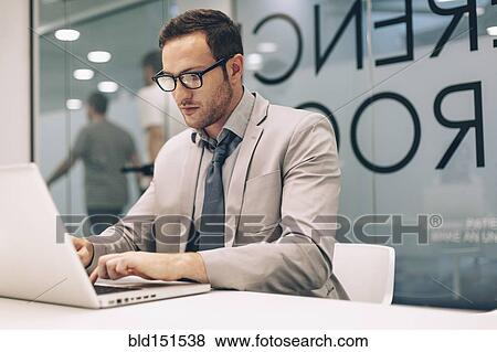 Caucasian businessman working on laptop in office View Large Photo Image Stock Photo - Caucasian businessman working on laptop in office. Fotosearch