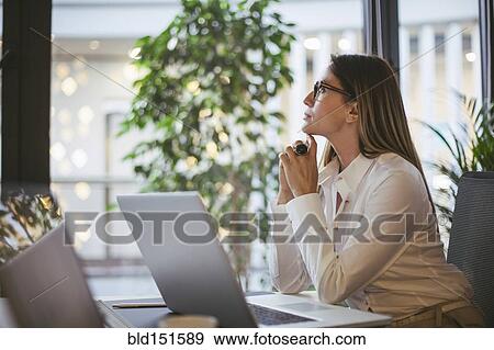 Caucasian businesswoman thinking at desk in office View Large Photo Image Stock Photo - Caucasian businesswoman thinking at desk in office. Fotosearch