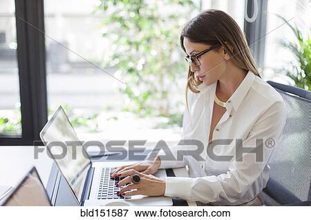 Caucasian businesswoman working at laptop at desk View Large Photo Image Stock Photo - Caucasian businesswoman working at laptop at desk. Fotosearch