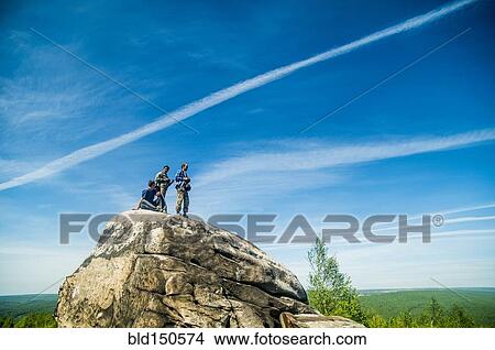 Picture - Caucasian climbers standing on rock formation. Fotosearch