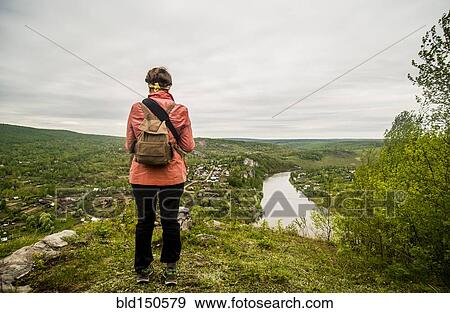 Caucasian hiker admiring scenic view of village View Large Photo Image Stock Photo - Caucasian hiker admiring scenic view of village. Fotosearch